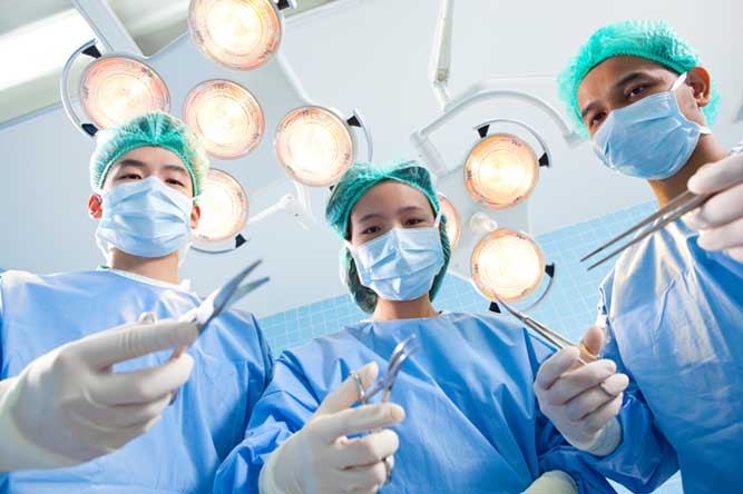 手術台で医者に囲まれる画像